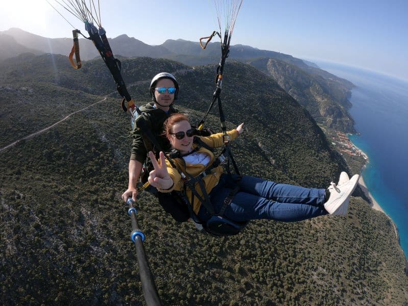Tandemový paragliding v Turecku. Dievča na padáku nad morom